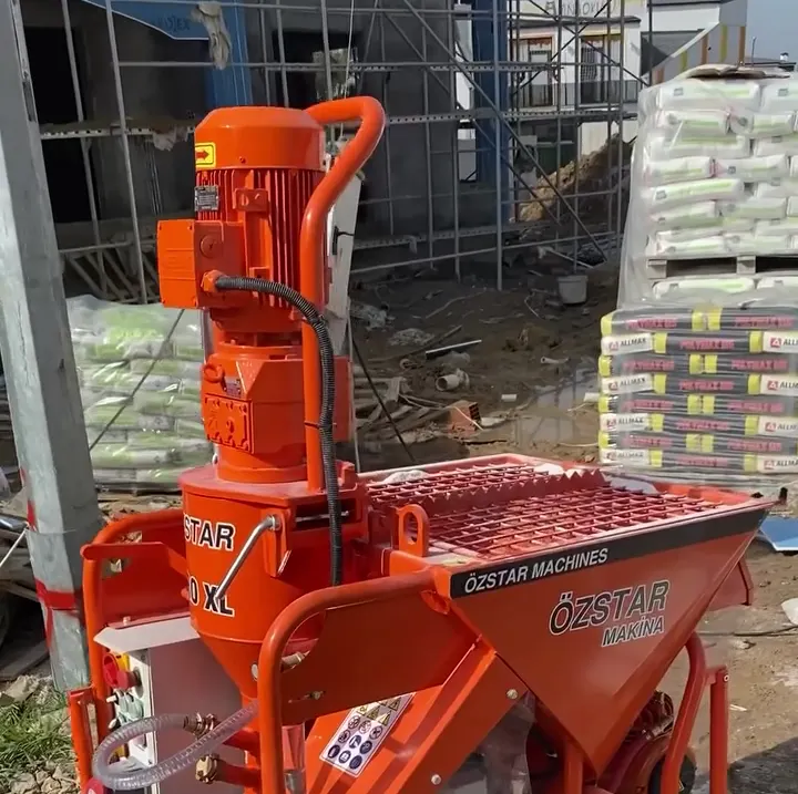 Şantiyede çimento torbalarının önünde duran Özstar Pro XL alçı sıva makinesi